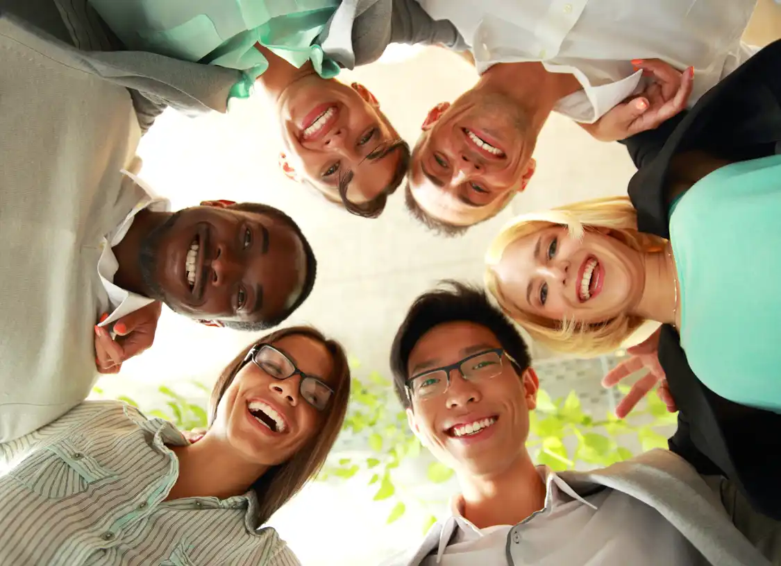 diverse group of people standing in circle smiling