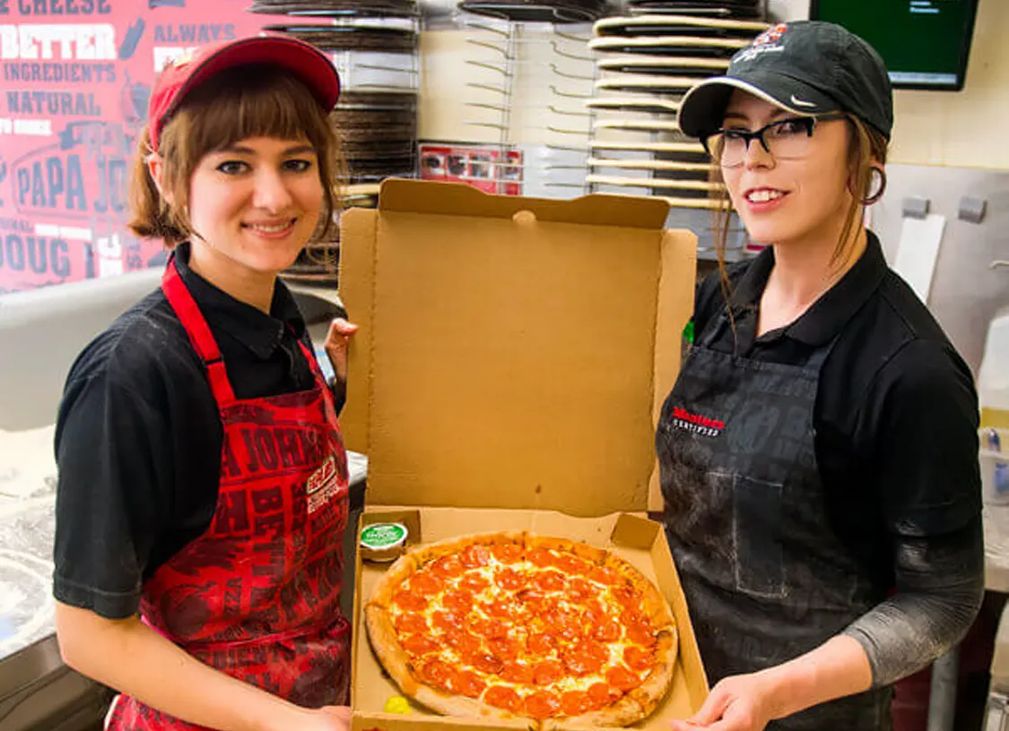 Two Papa Johns pizza makers holding open pizza box