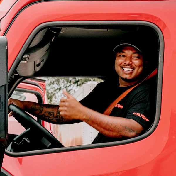 Truck driver giving thumbs up while seated in his truck